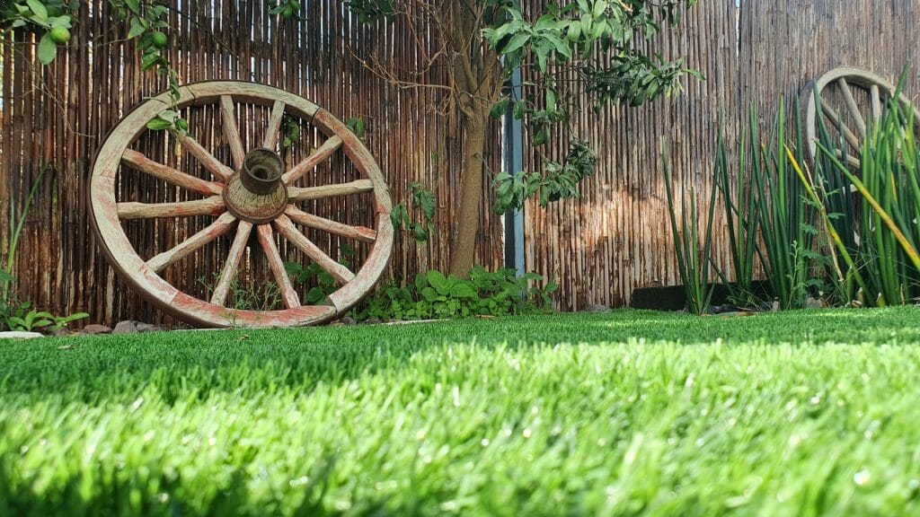 גלגל כרכרה עתיק לצד דשא סינטטי